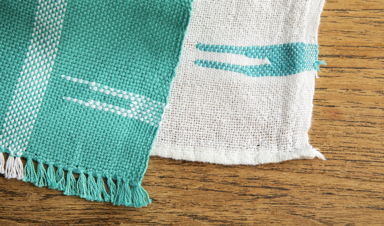 Left: loose teal towel with white pattern; right: fine white towel with teal pattern