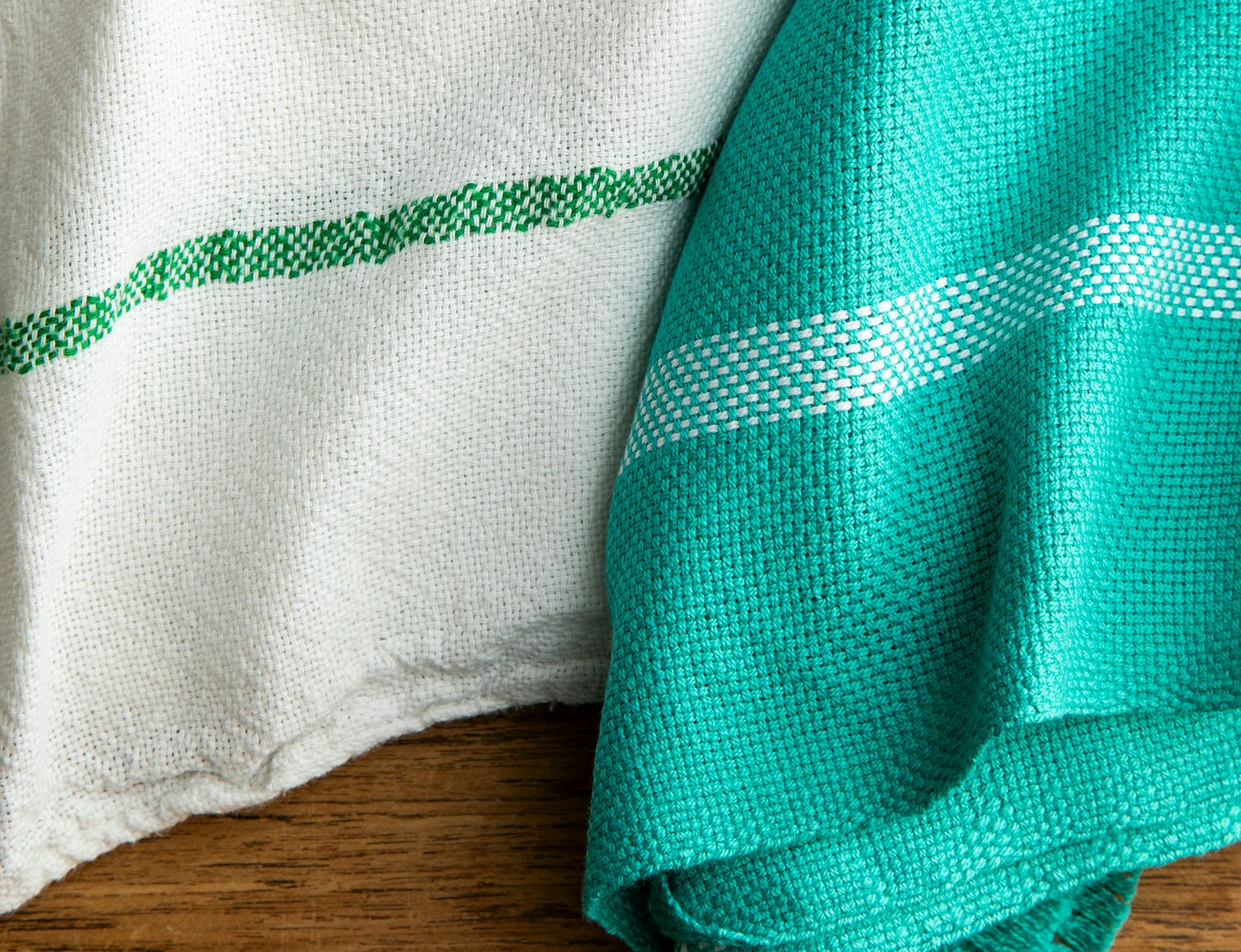 Left: fine white towel with green stripe; right: looser teal towel with white stripe