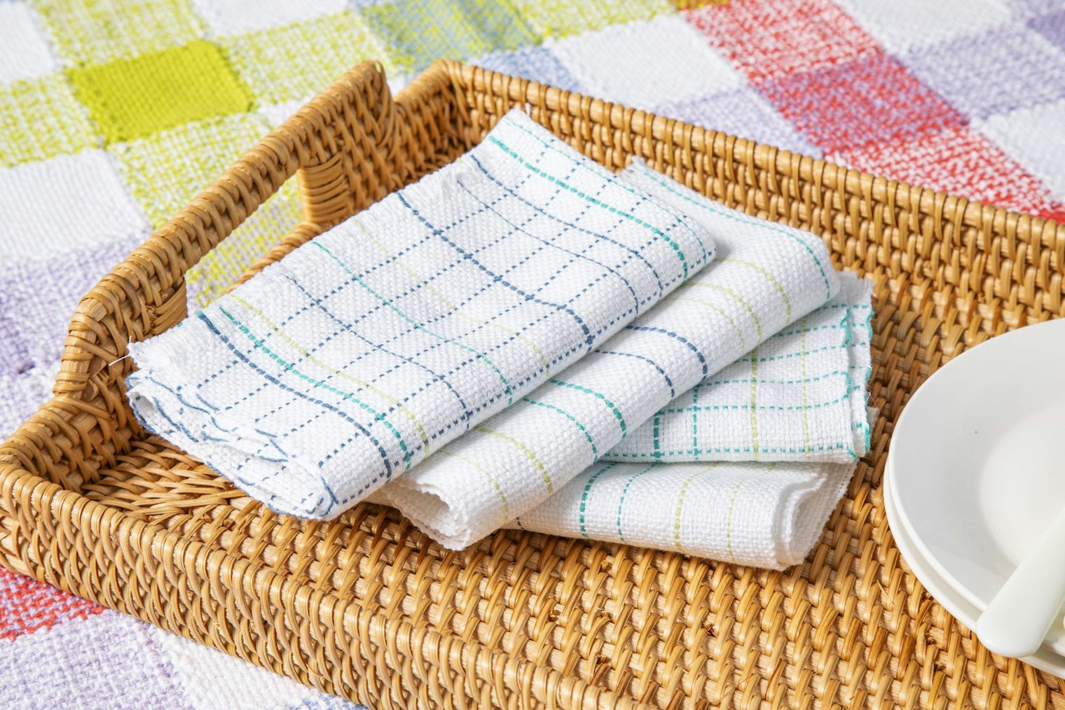 Anthony Thompson's Lovely Day Picnic Blanket uses different colors of pin-loom squres to create a cheery checked blanket, while Sara Goldenberg White's  Just a Dash Napkins showcase how even some simple stripes can make a big impact. Both projects are from the Summer 2026 issue. Photo by Matt Graves