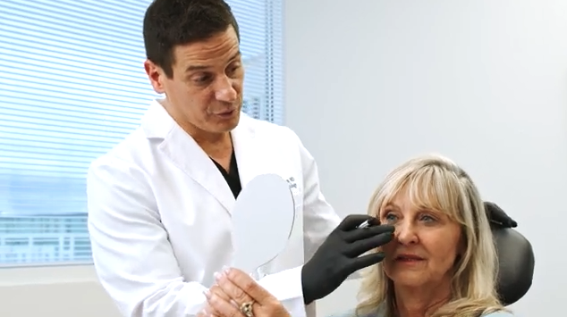Dr. Greco looking at a patient's skin
