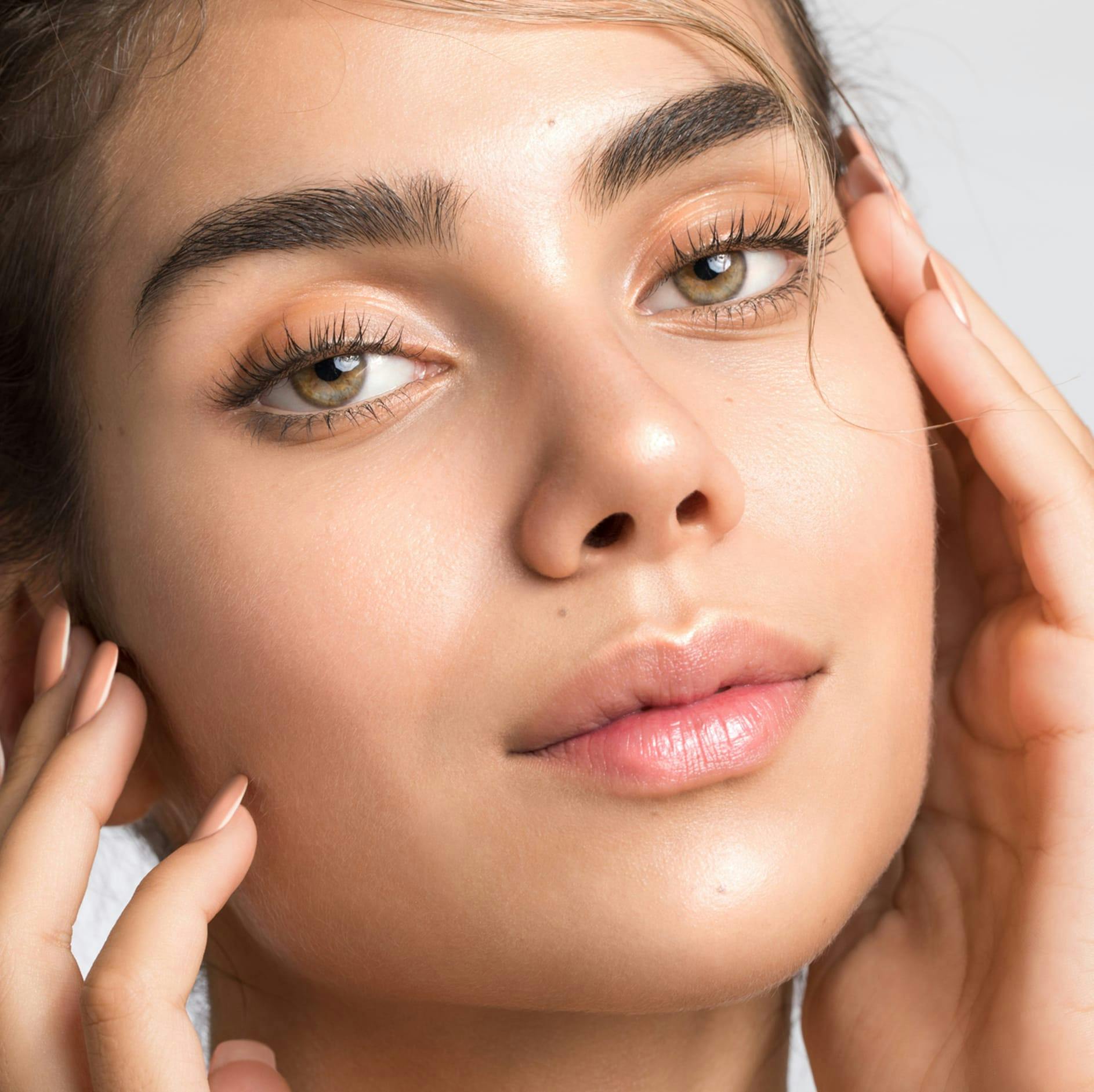 woman with green eyes and hands on her face