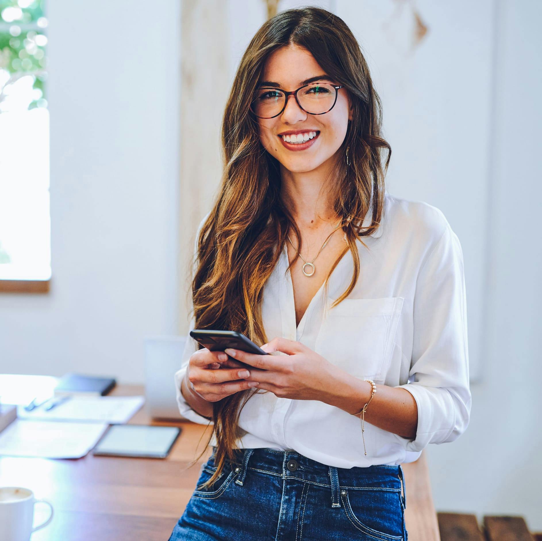 woman with long brown hair and glasses smiling