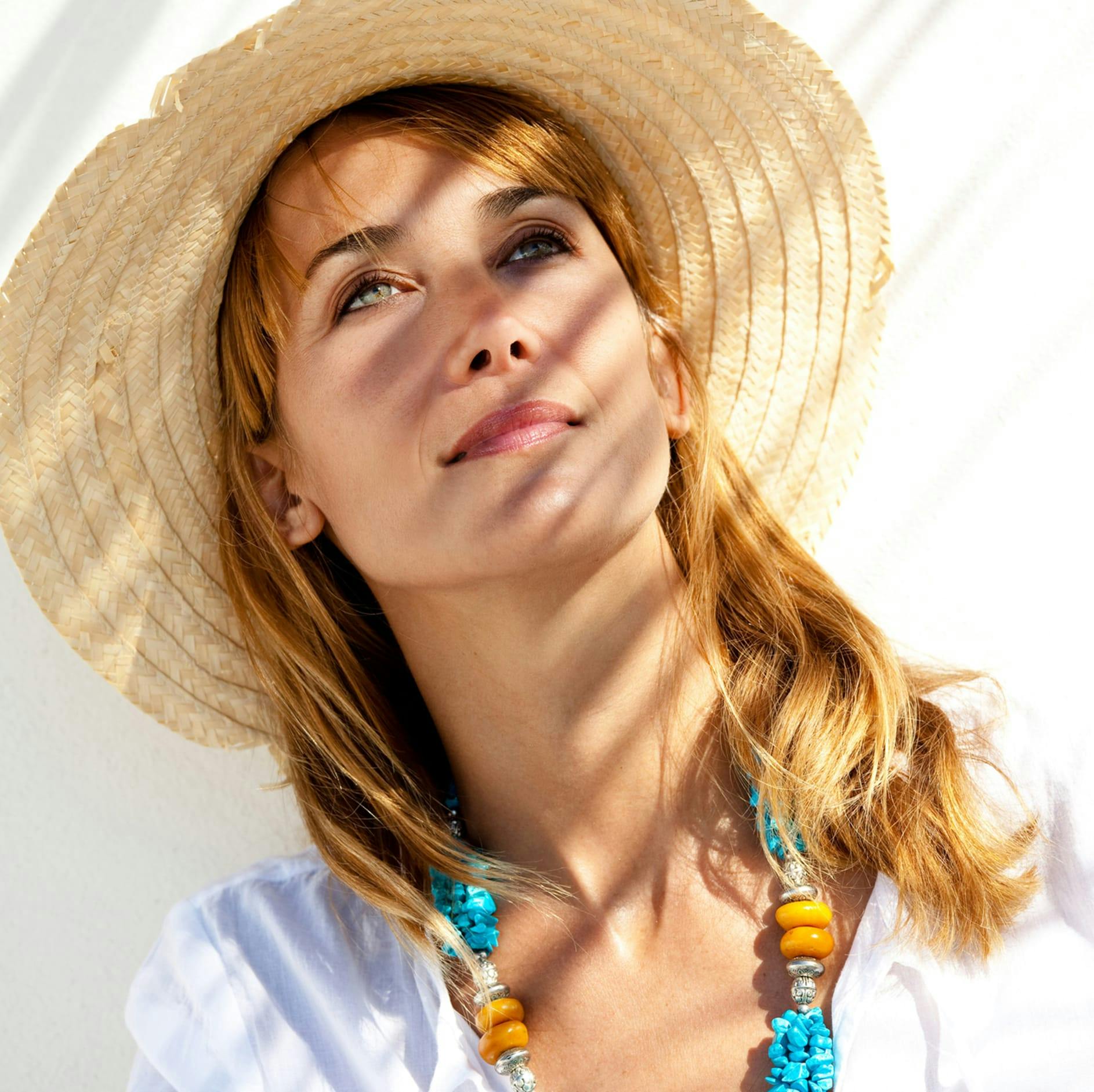 woman with red hair and straw hat
