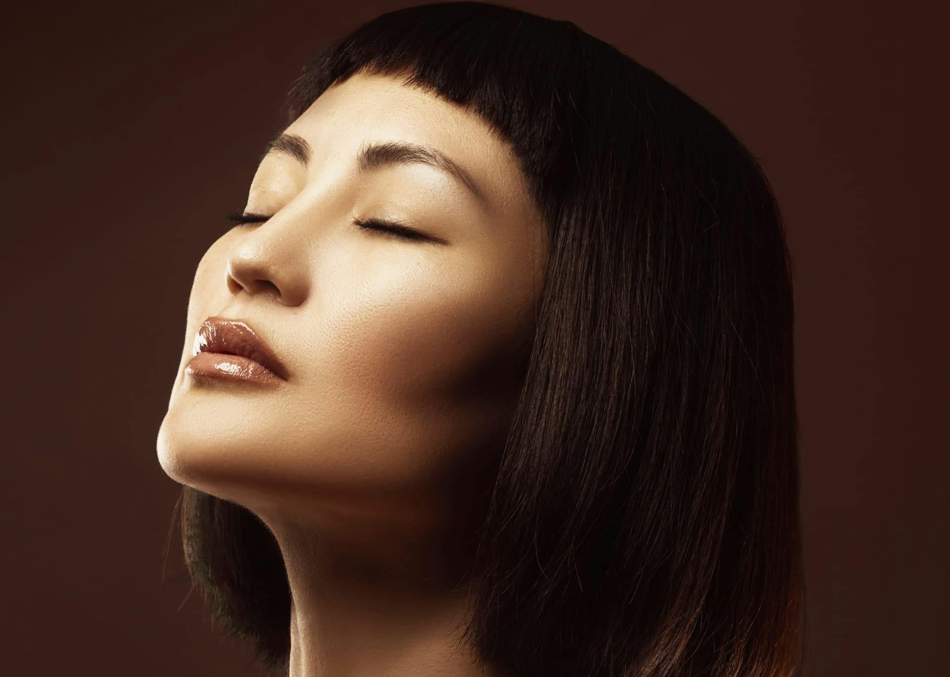 woman closing her eyes and a short bob and bangs