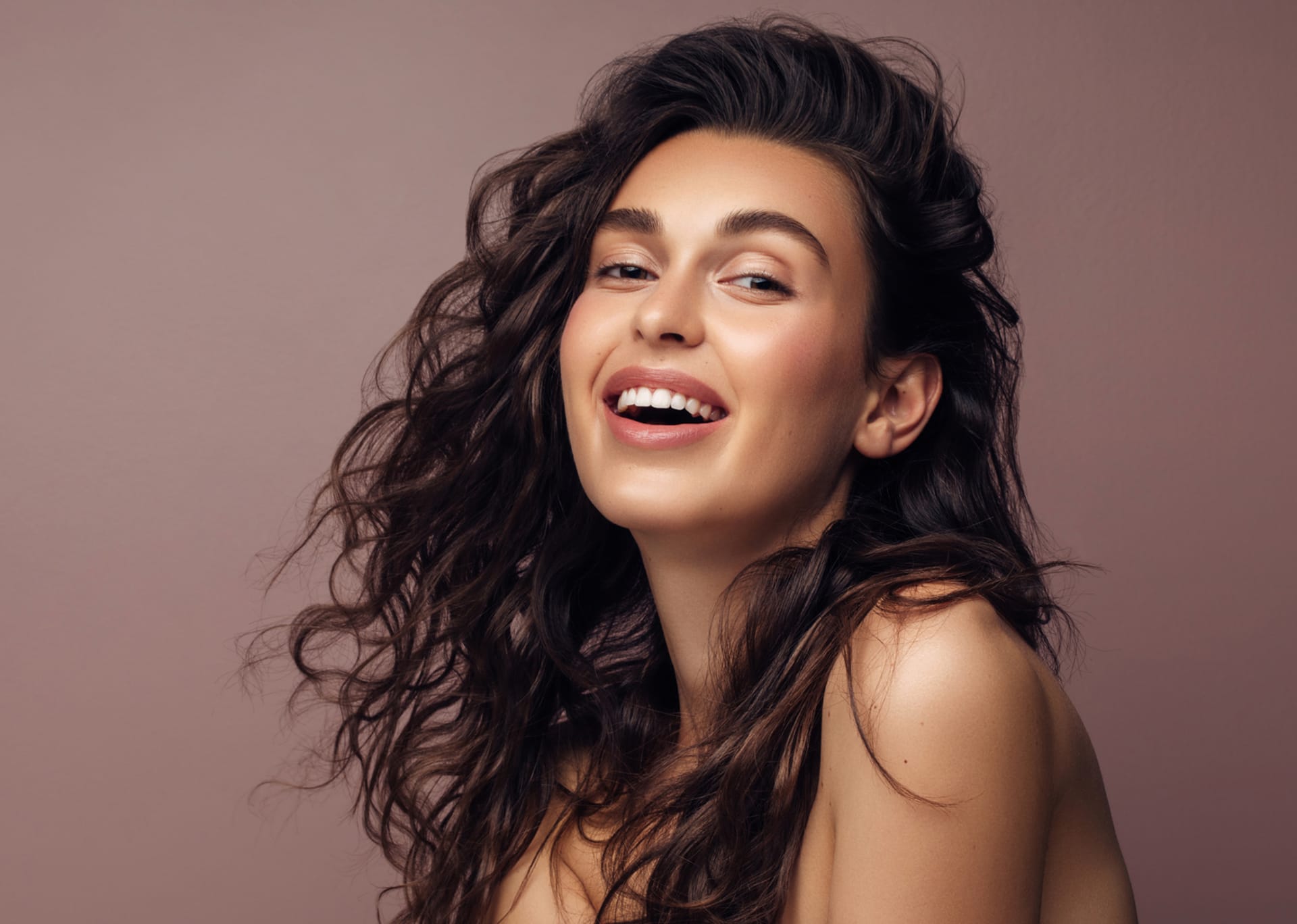 woman with long curly hair smiling