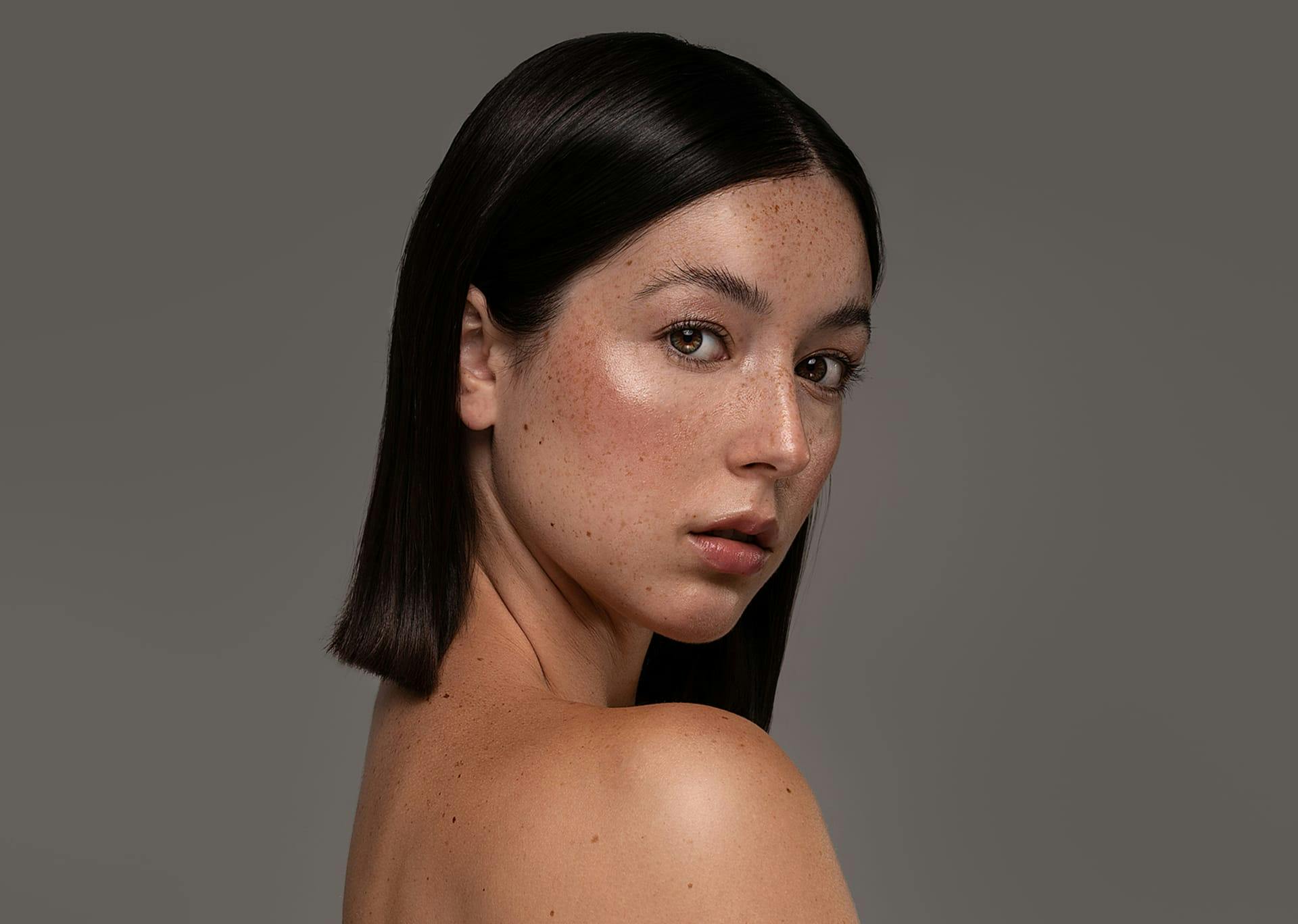 woman with short brown hair looking over her shoulder