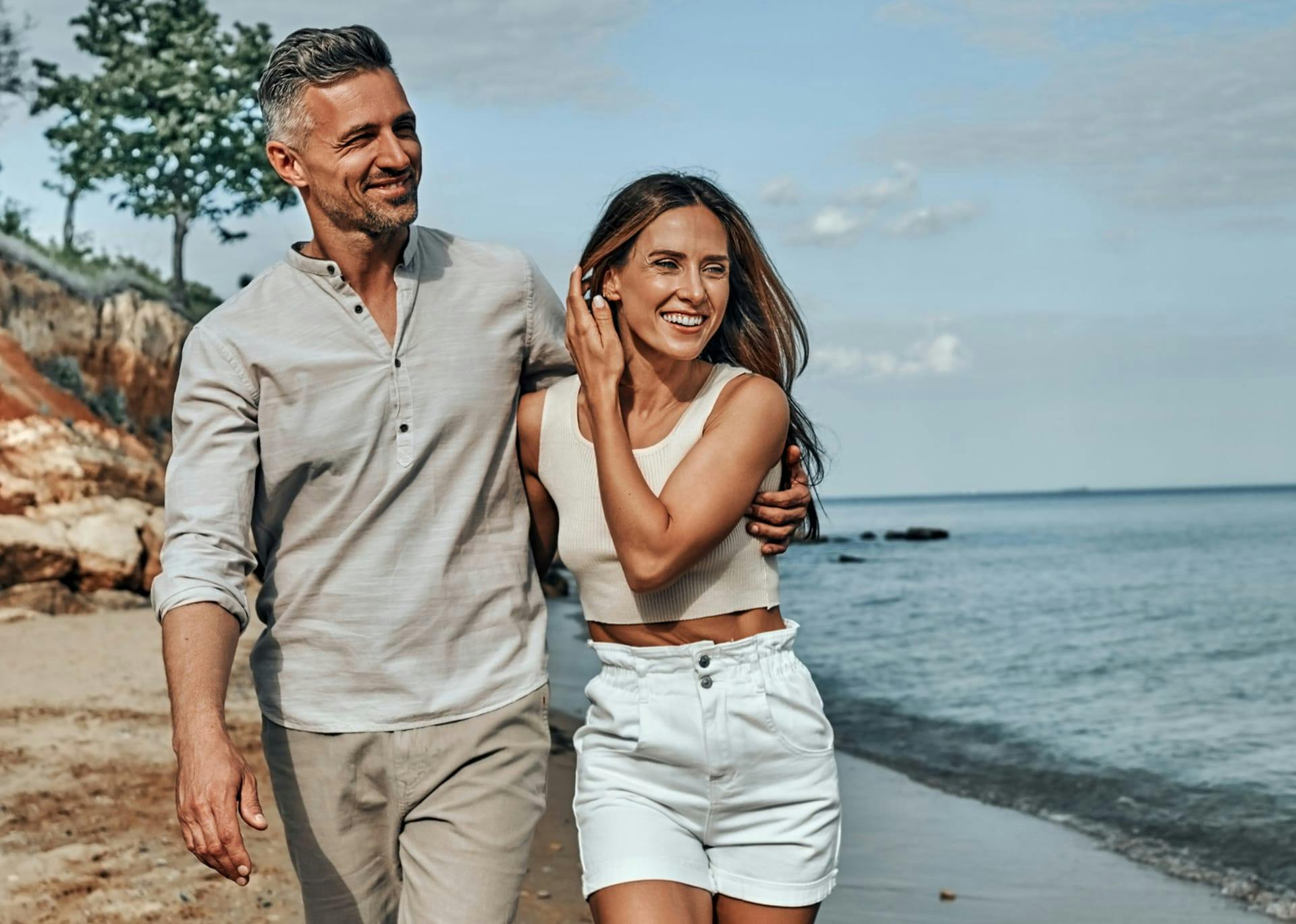 man and woman walking on the beach