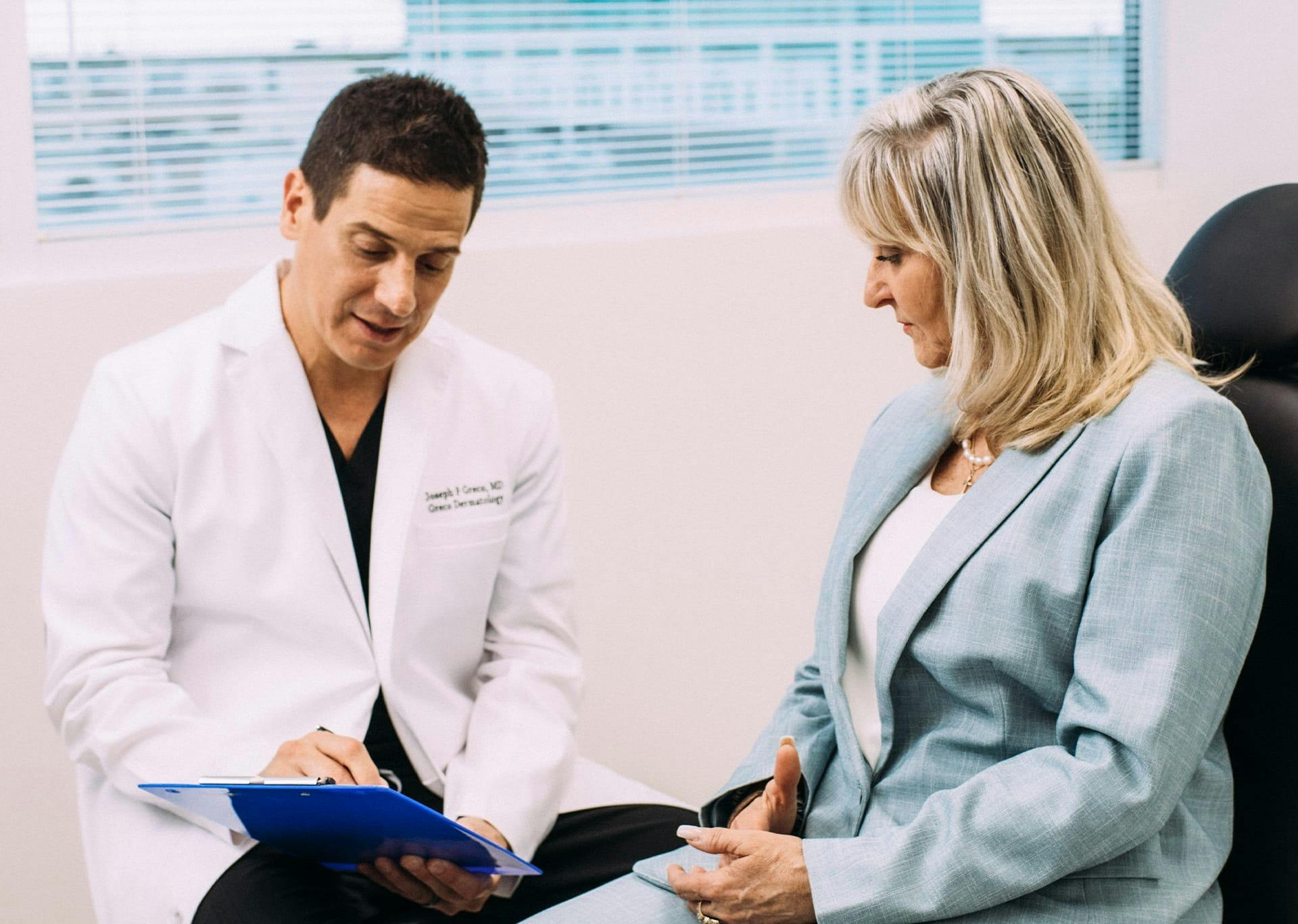 Dr. Joseph F. Greco III showing a patient a form