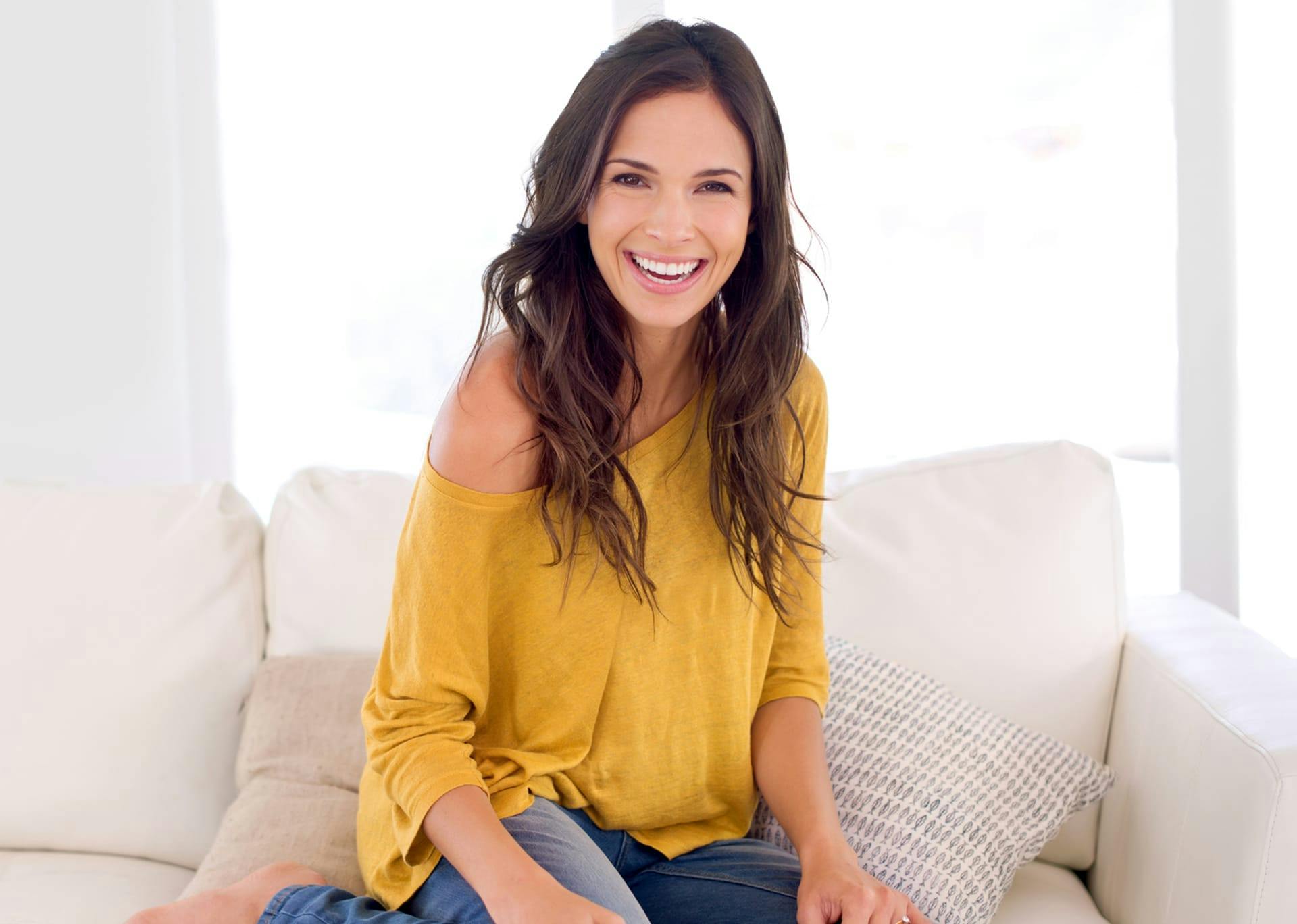 woman on a couch smiling