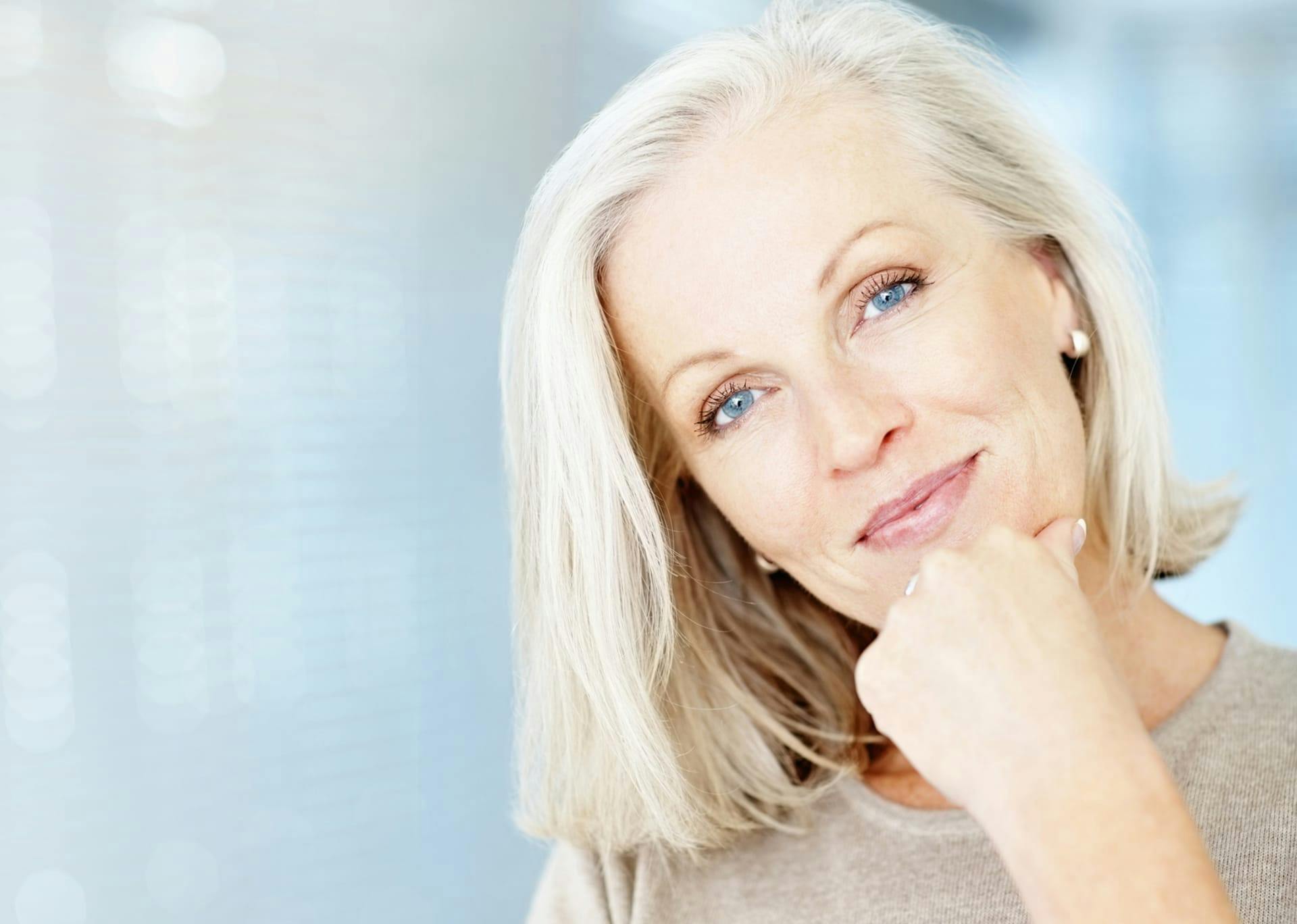 woman smiling with her hand on her chin
