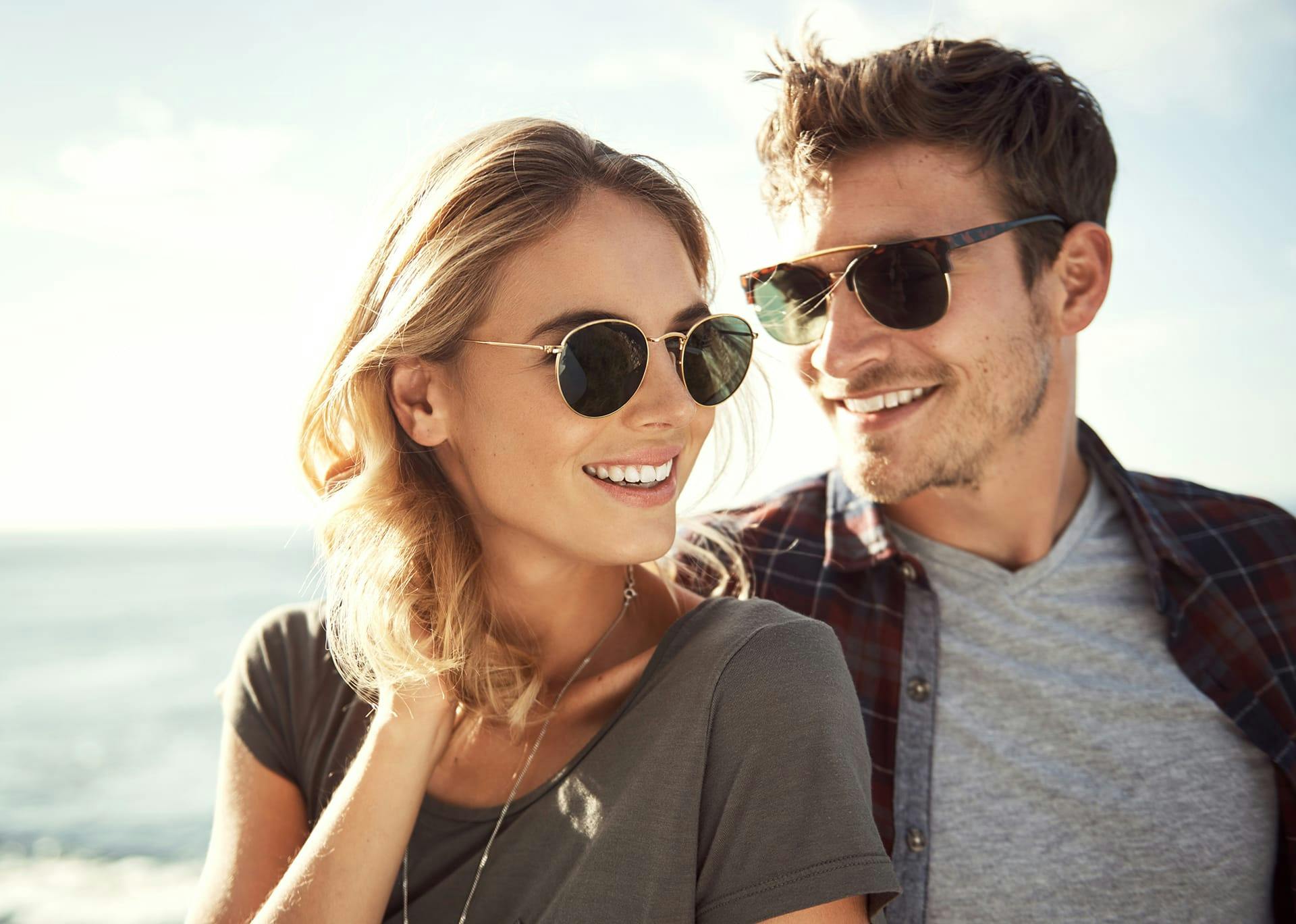 woman with glasses on and guy smiling behind her