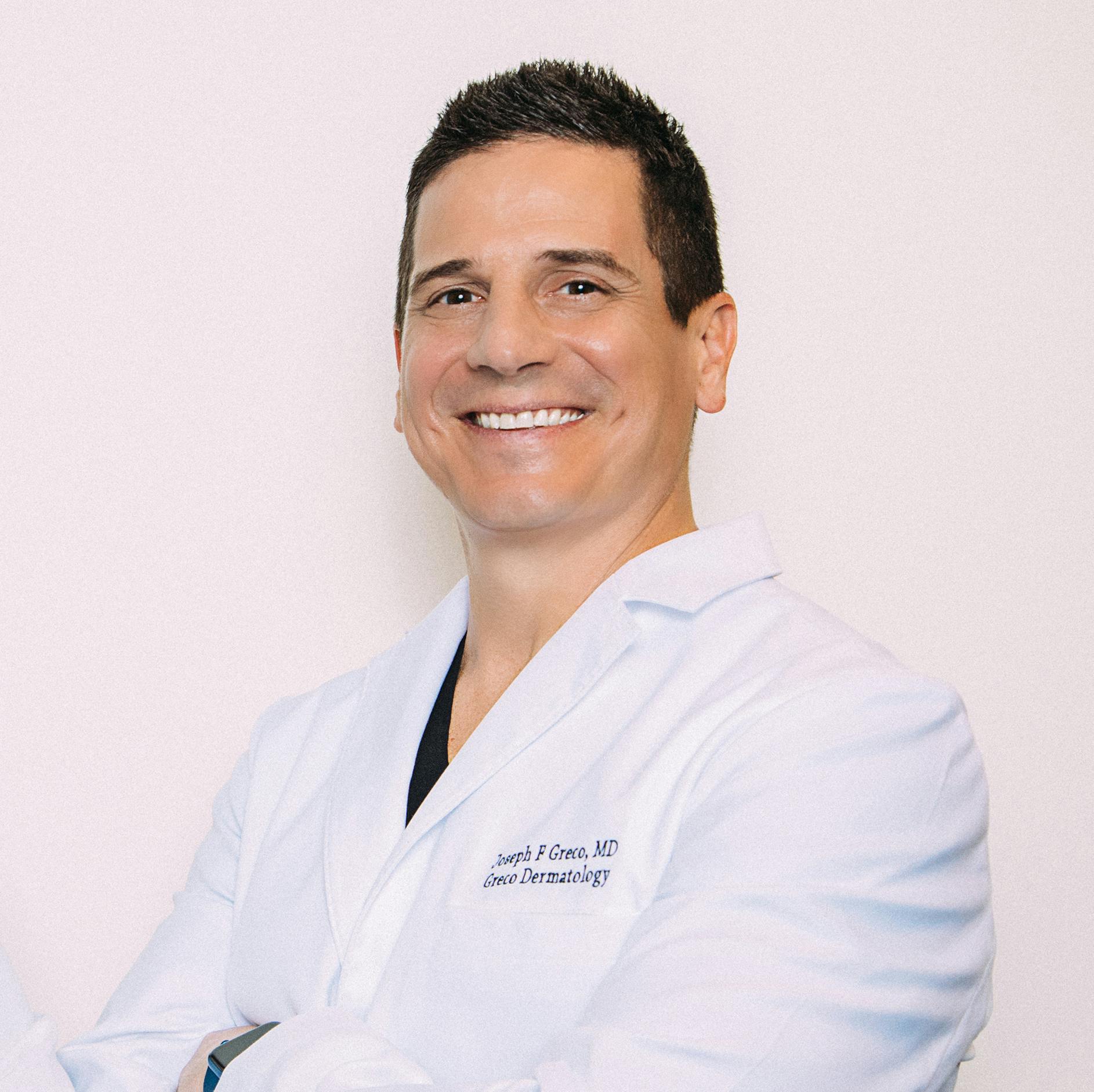 Dr. Greco smiling in a lab coat