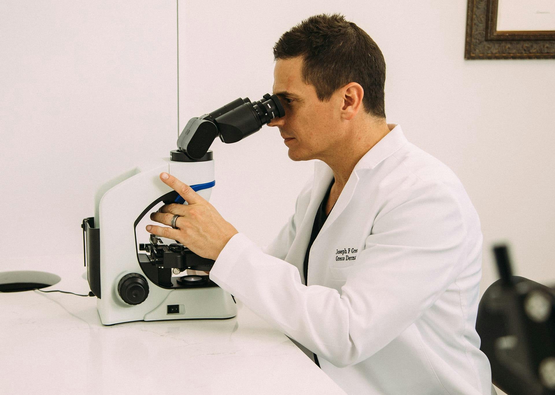 Dr. Greco looking through a microscope