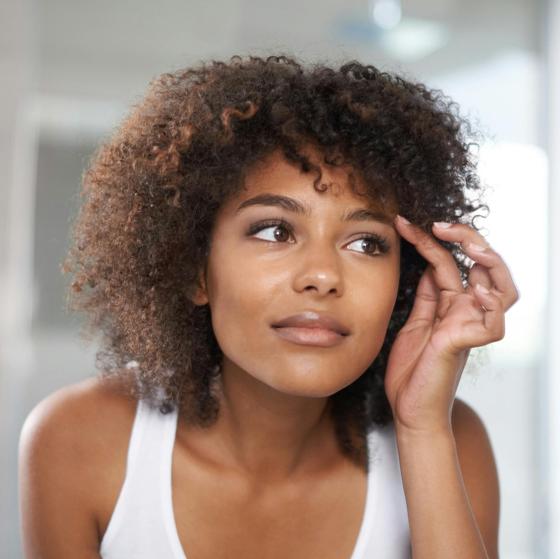 woman with brown curly hair looking to the side