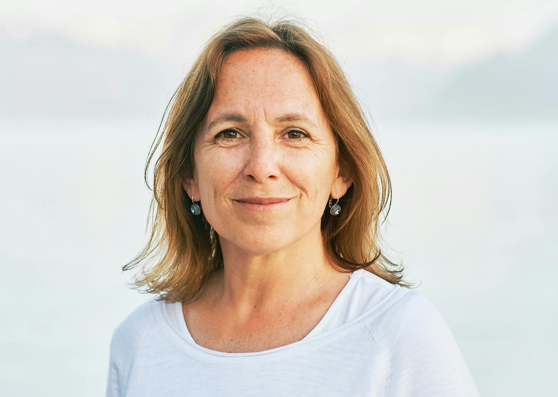 woman with light brown hair smiling at the camera