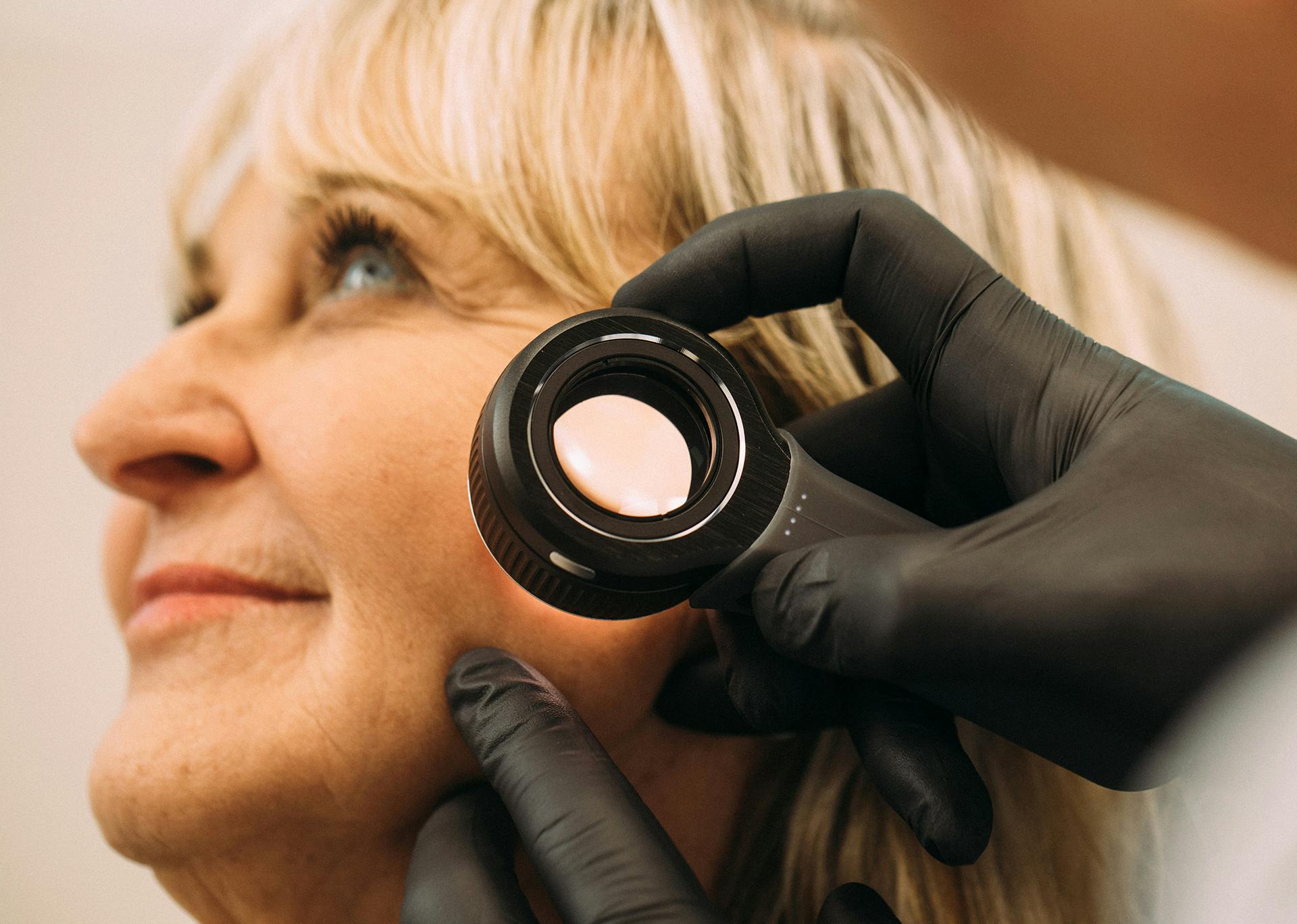 patient with the Dr. looking at her skin through a microscope