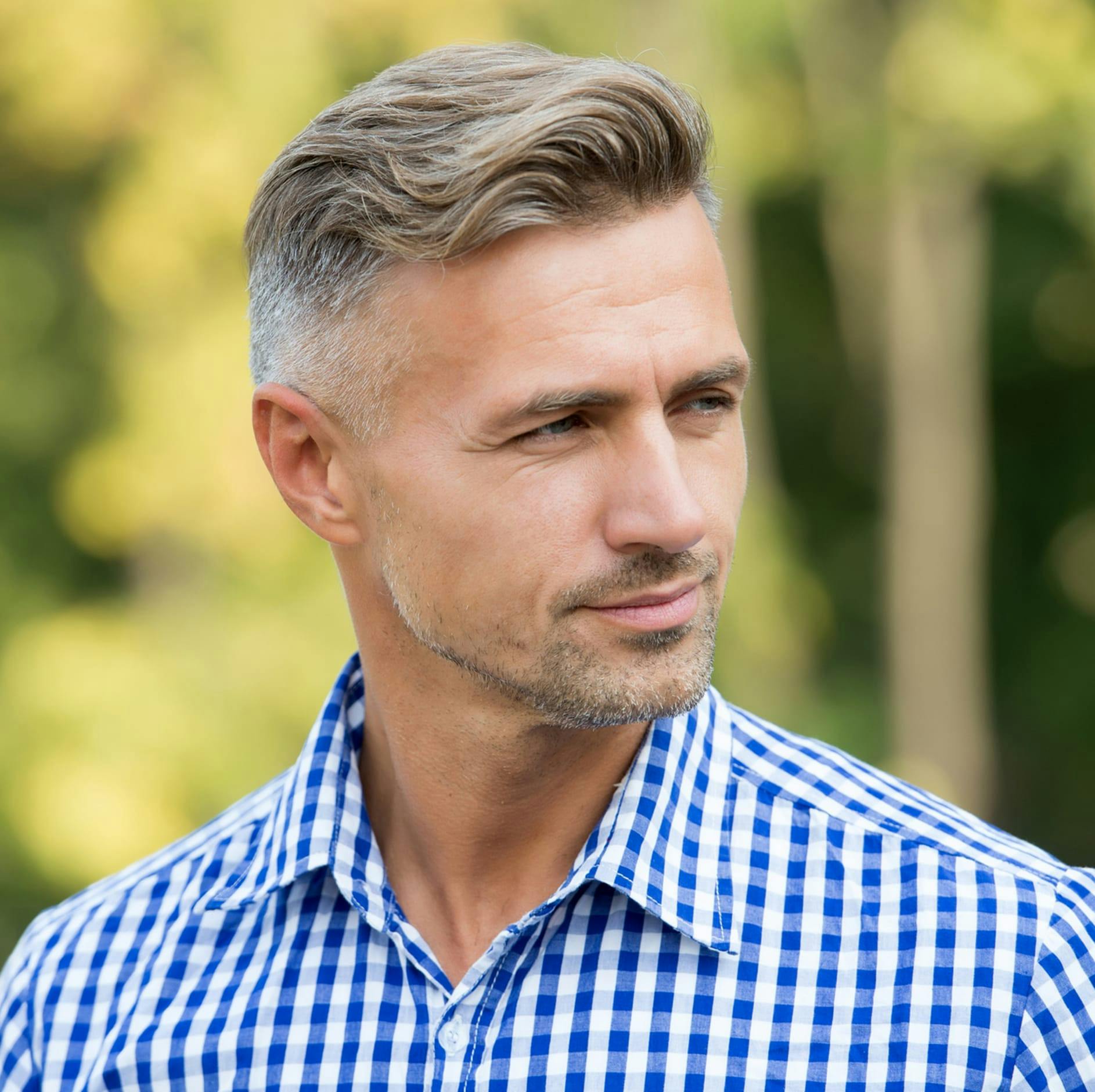 man with a blue checkered shirt on looking to the side