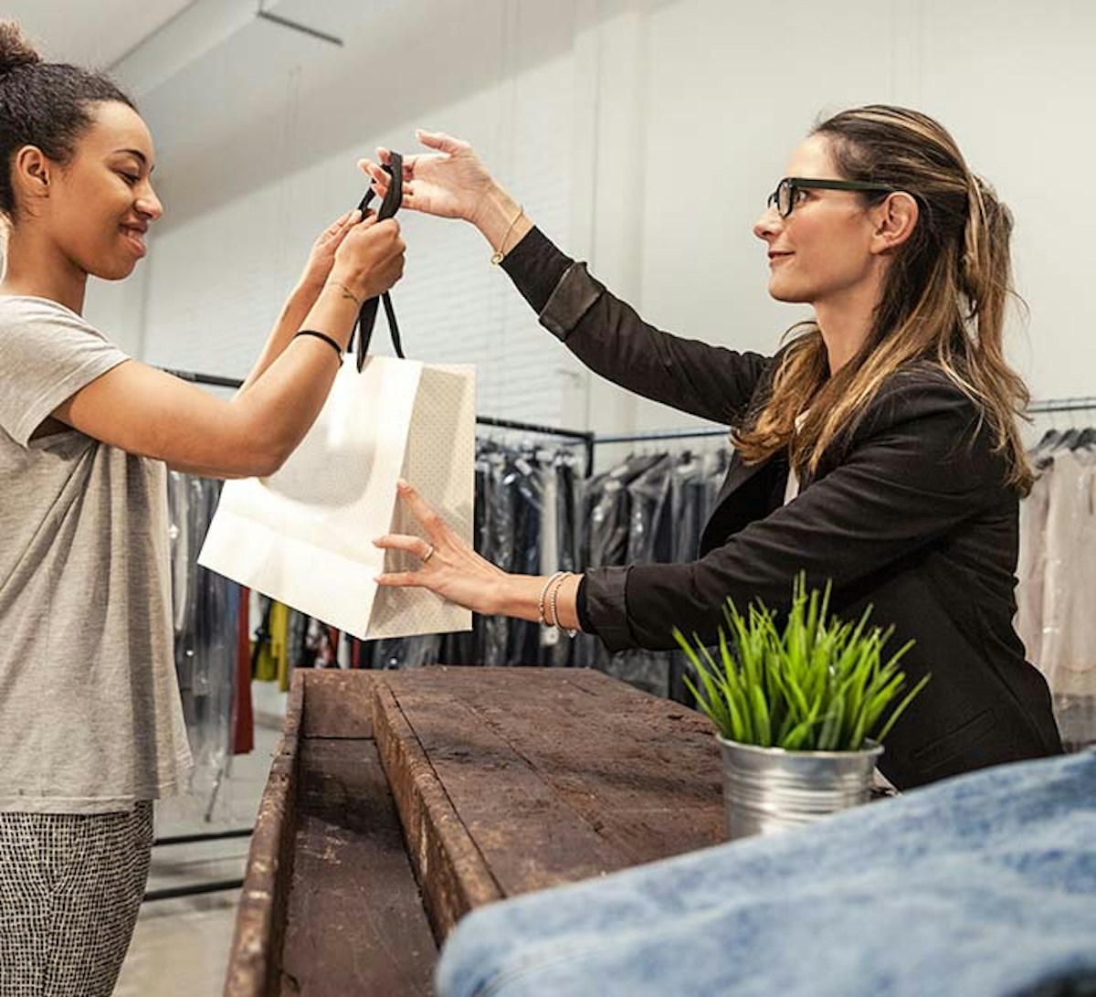 Retail Manager handing a shopping bag to customer