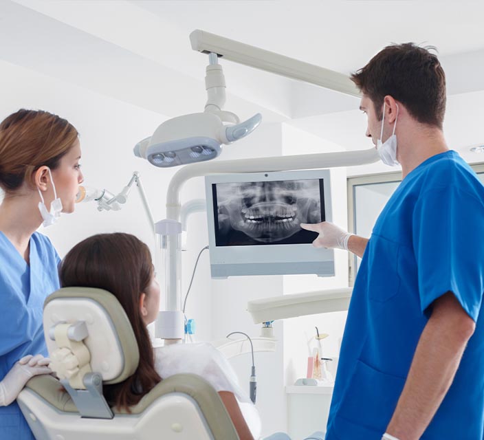 Dental Assistant looking at x-ray with client