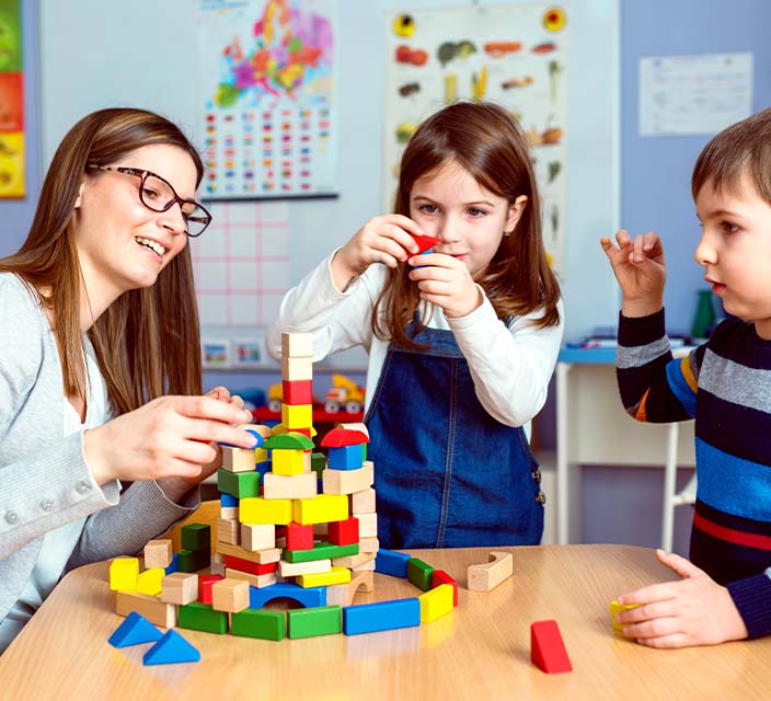 Childcare Educator with children playing blocks