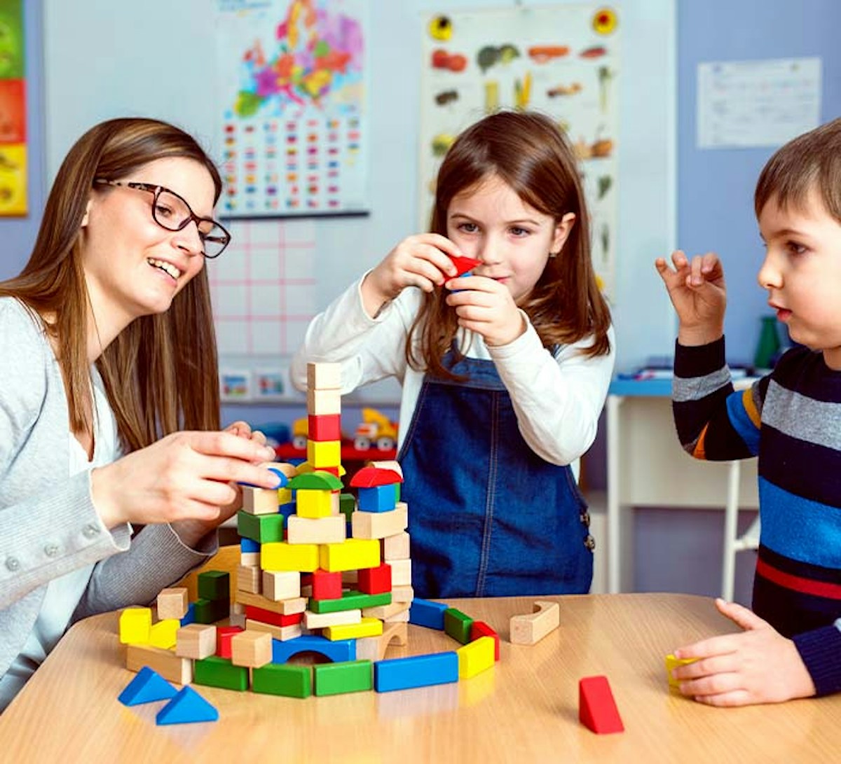 Childcare Educator with children playing blocks