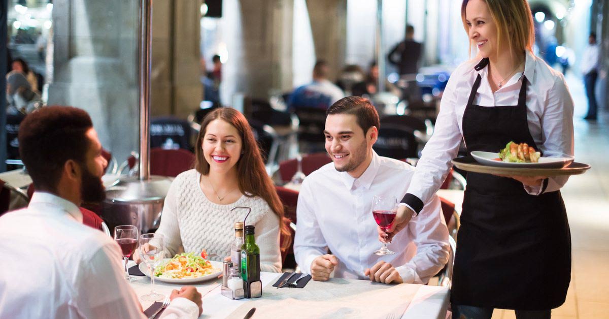 Hospitality professional enjoying a conversation with restaurant customers