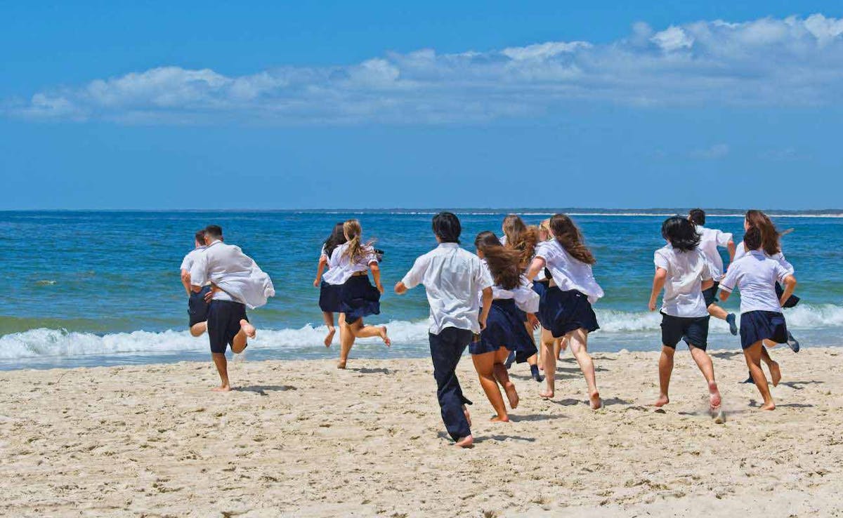 School kids running on beach