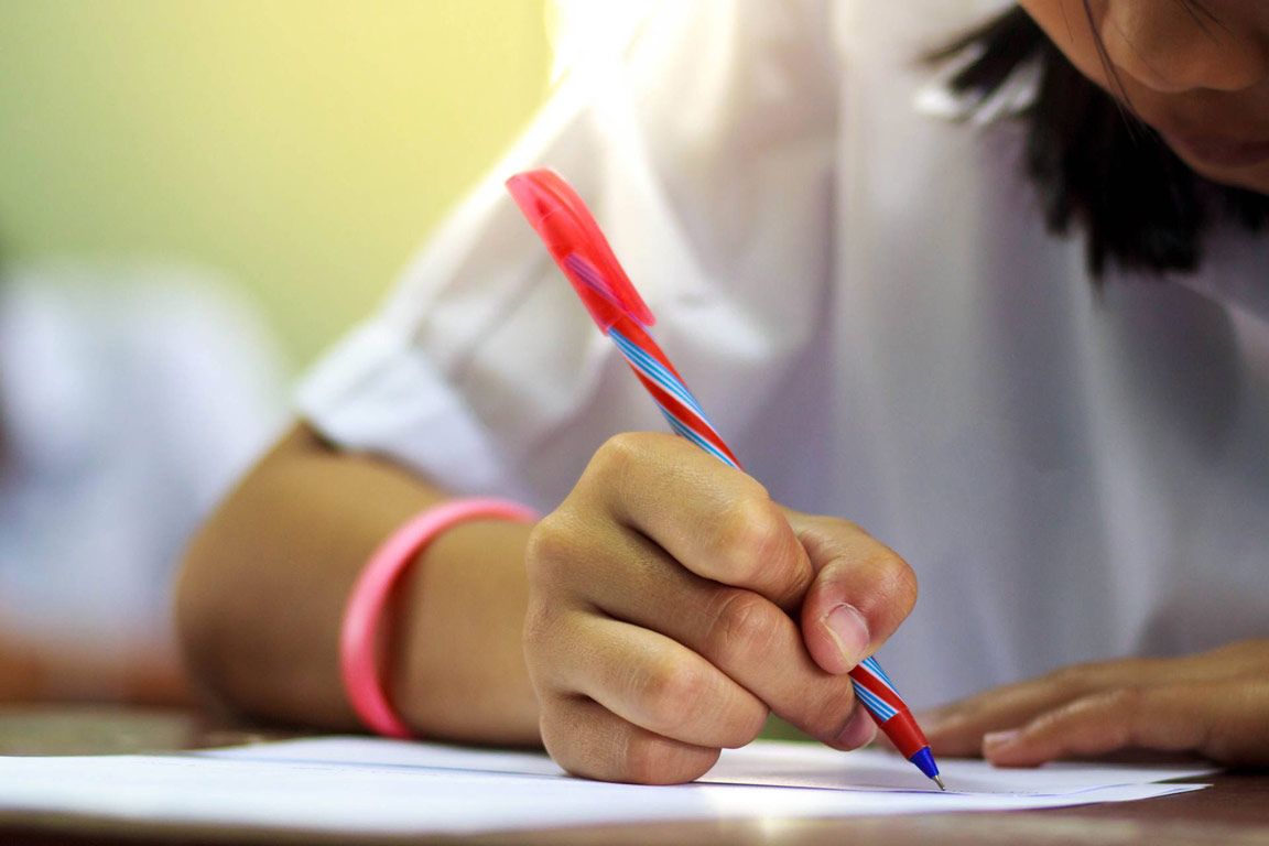 Student with Dysgraphia writing notes in the classroom