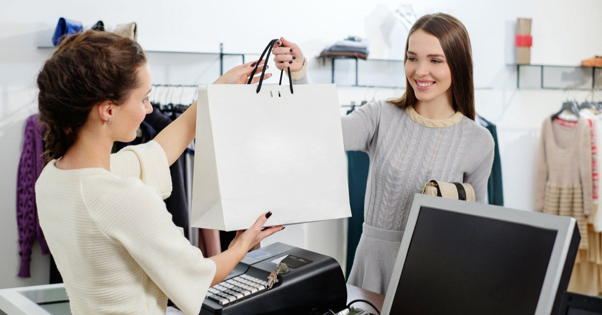 Retail manager handling a purchase with a customer