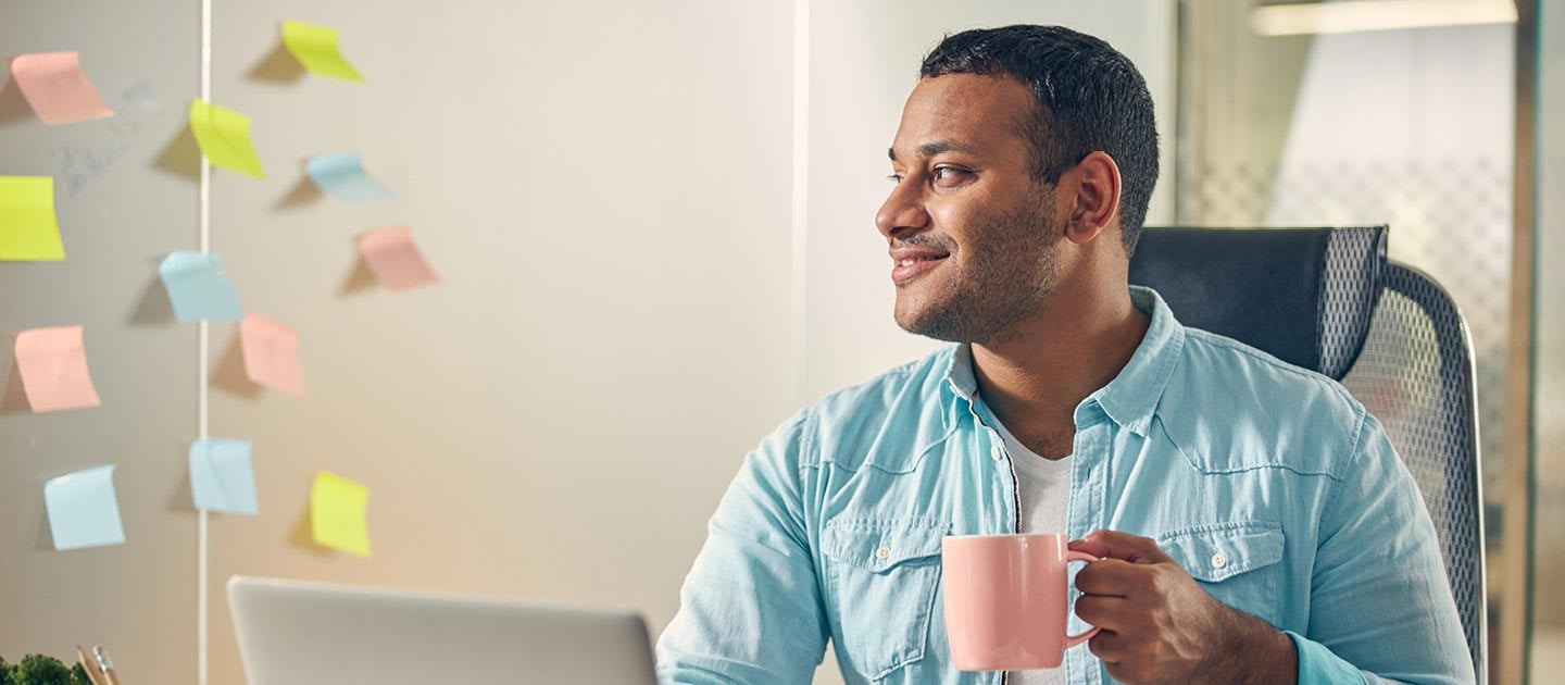 Man with coffee working in office