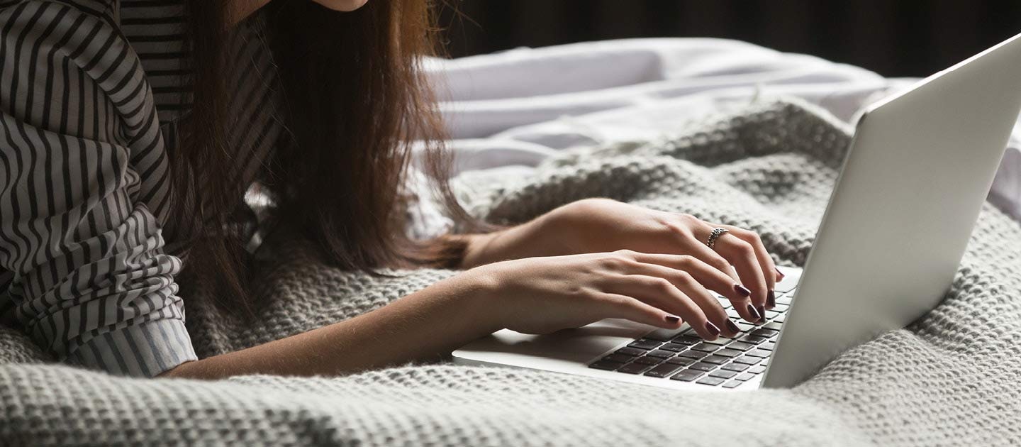 Woman on bed using laptop