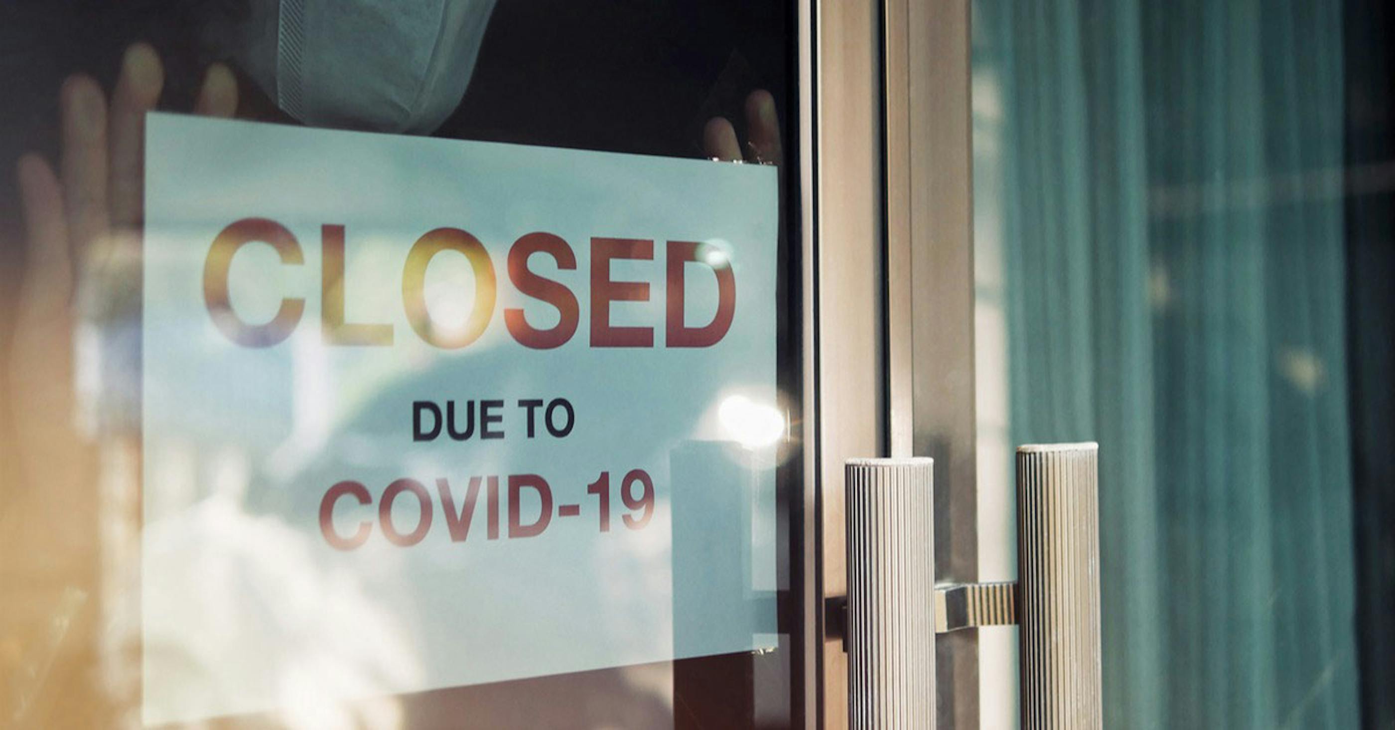 Storefront placing a closed sign due to COVID-19