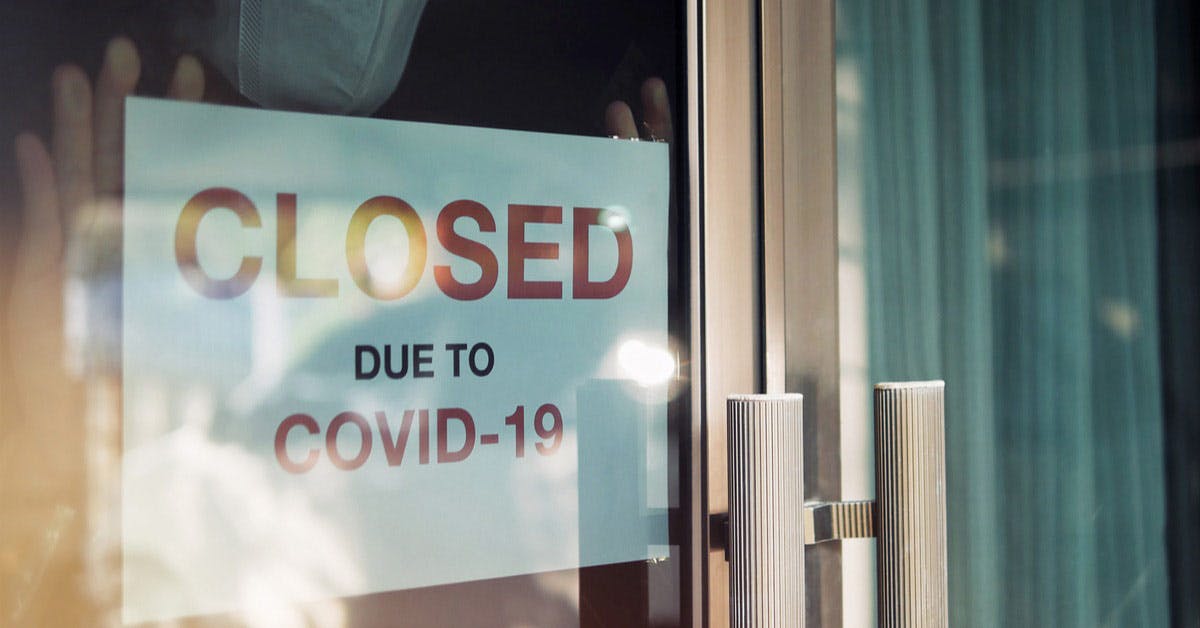 Storefront placing a closed sign due to COVID-19