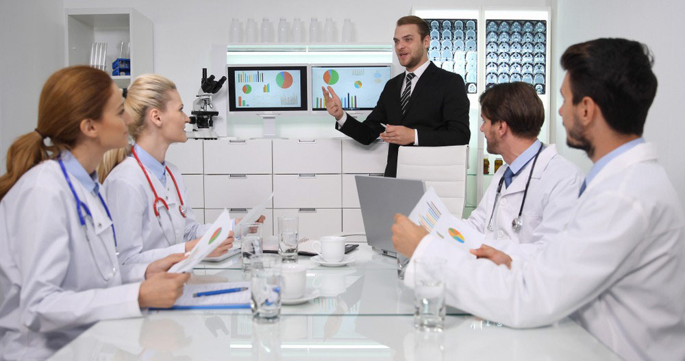 Hospital administrator discussing internal data with doctors 