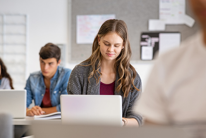 Young girl on laptop in a classroom