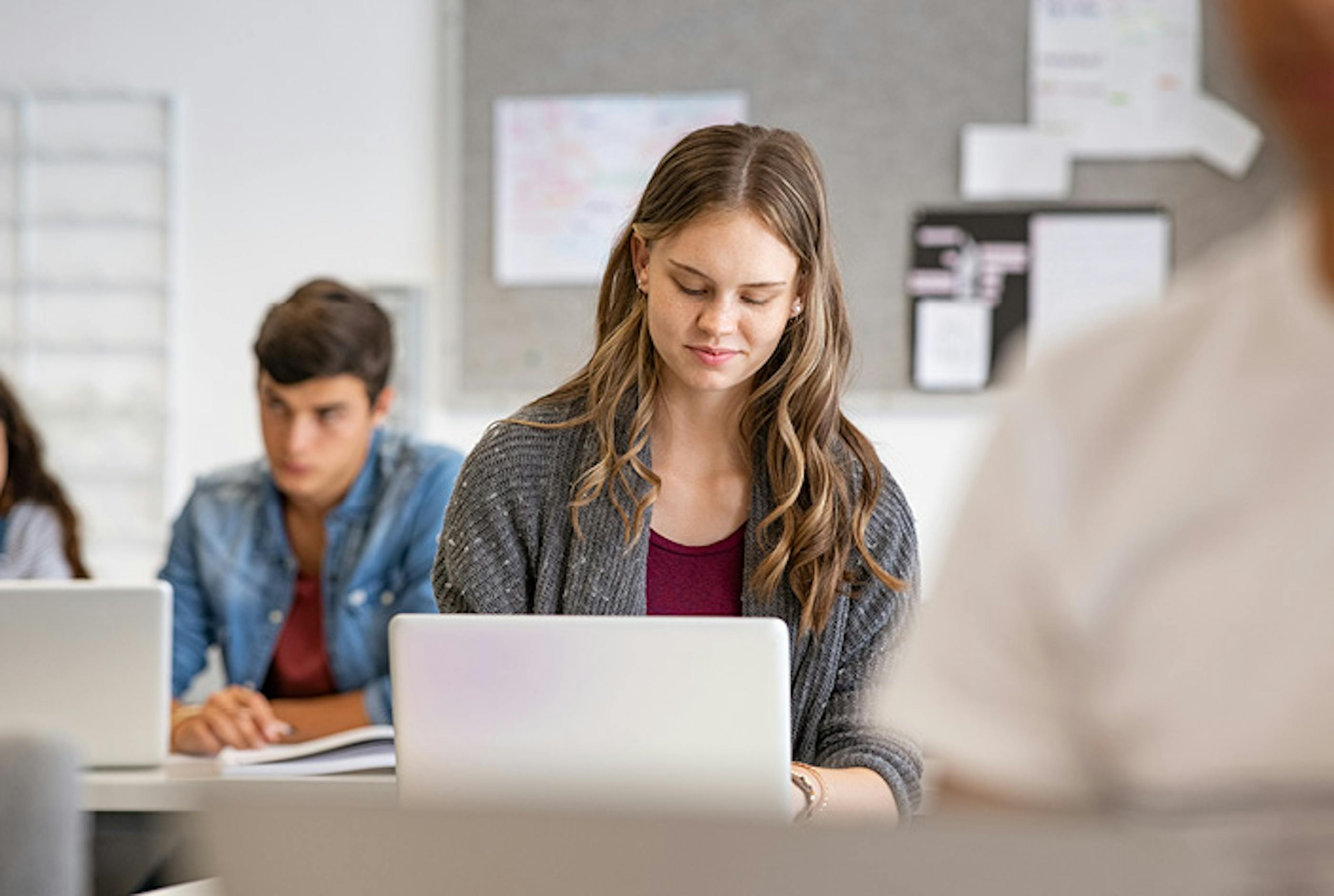 Young girl on laptop in a classroom