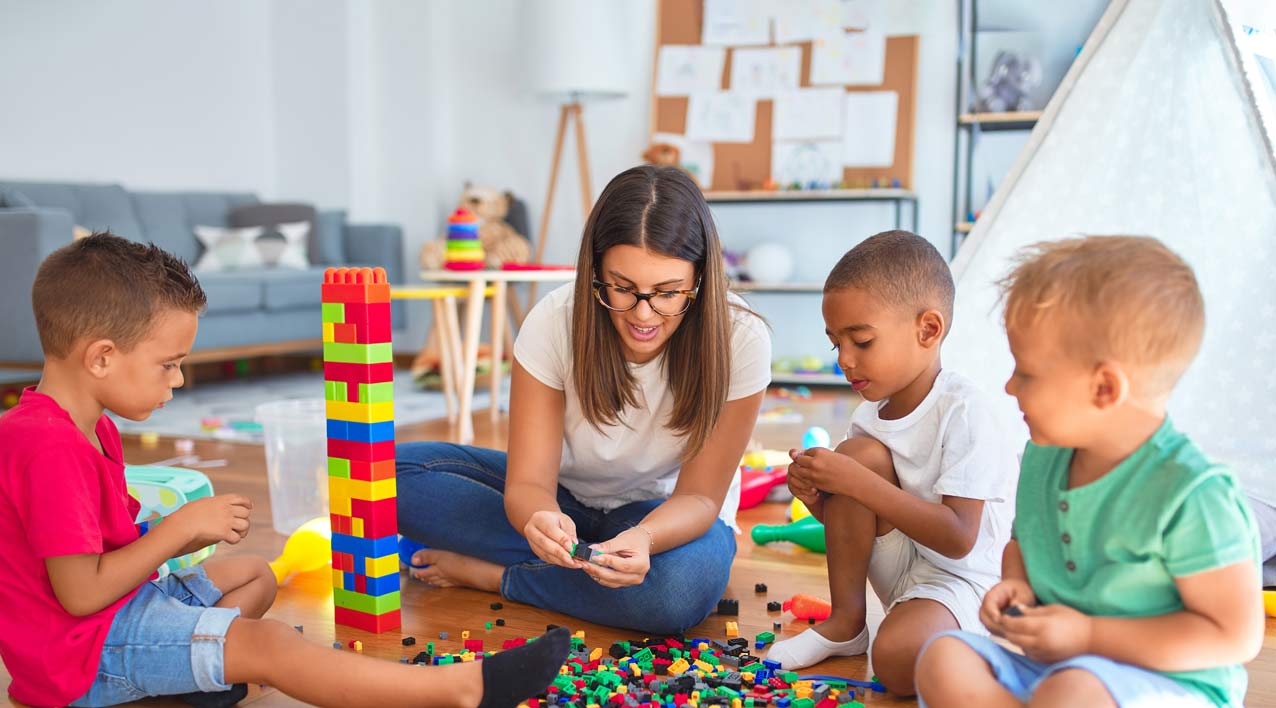 childcare assistant helping children play