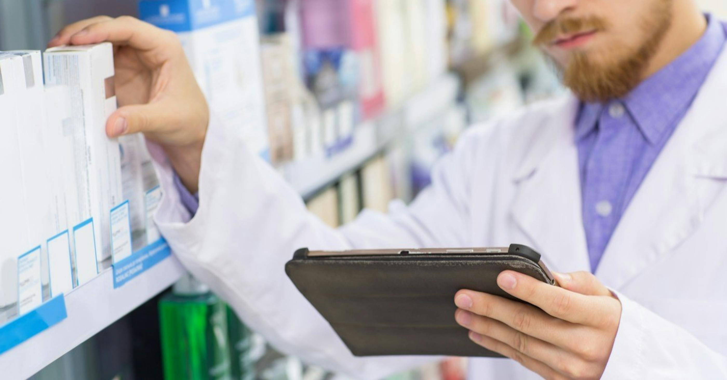 Pharmacist with digital tablet while doing stock update