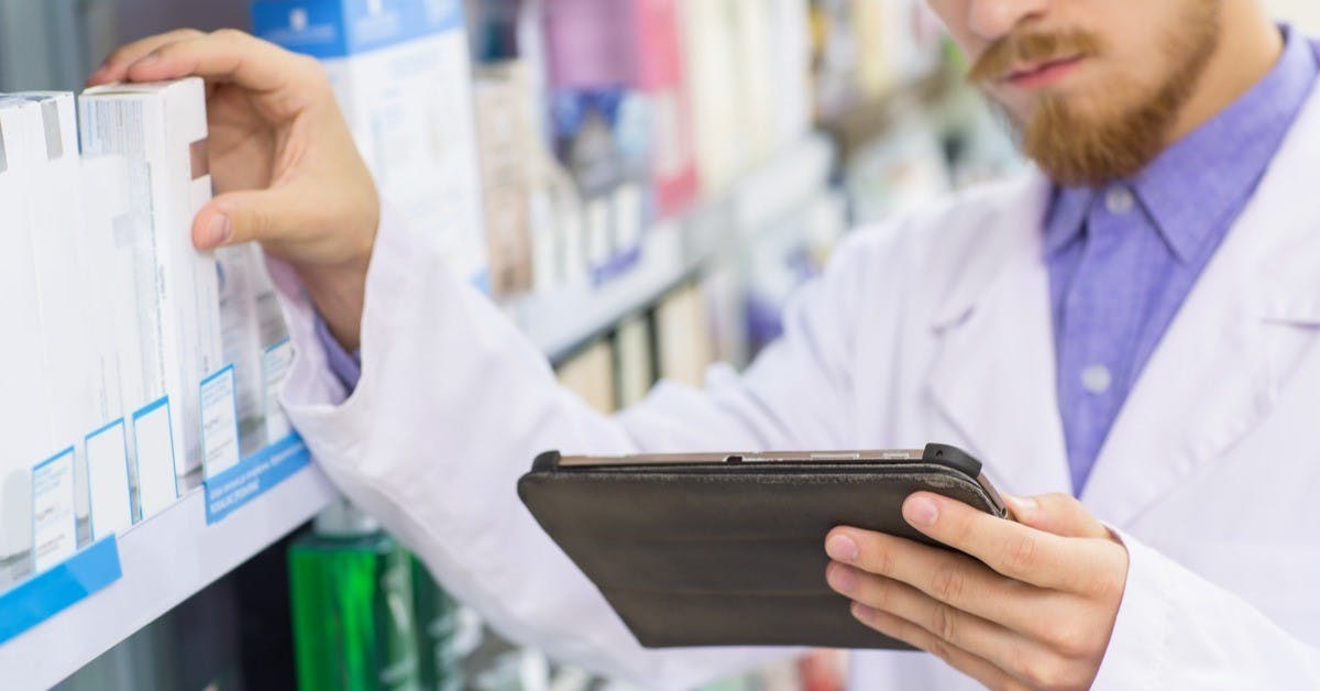 Pharmacist with digital tablet while doing stock update