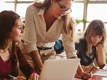 Teacher aide surrounded by students