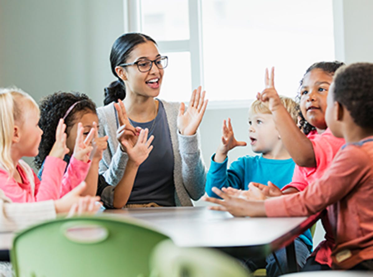 Early childhood educator surrounded by children