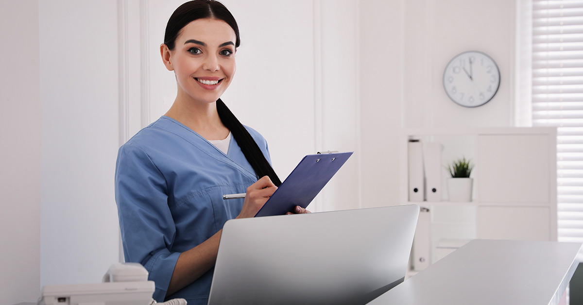 Medical Receptionist Writes on Clipboard