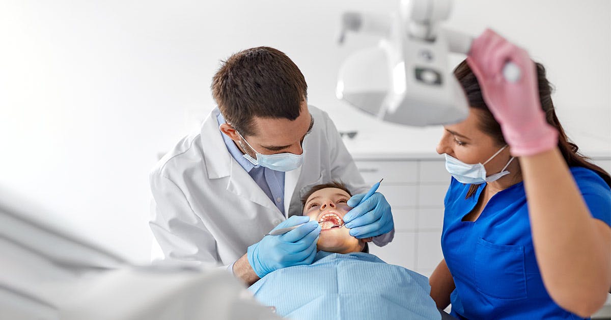 dentist and dental assistant with patient