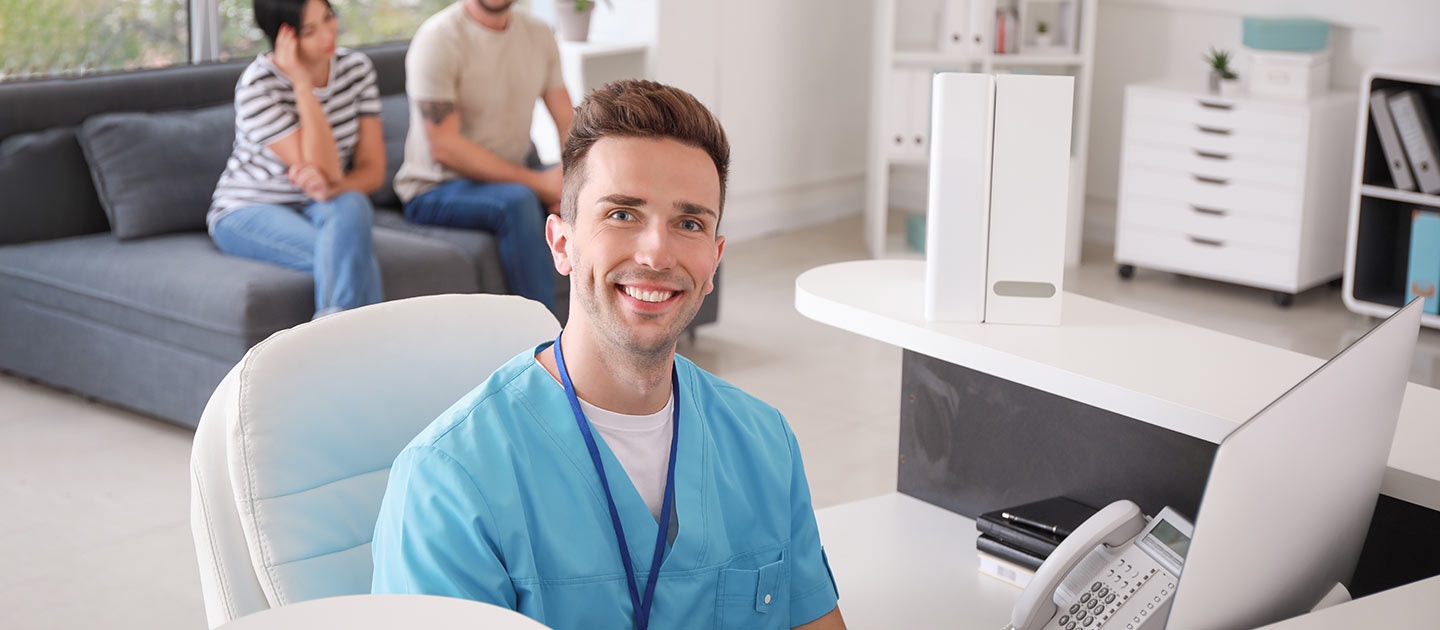 medical receptionist at his desk