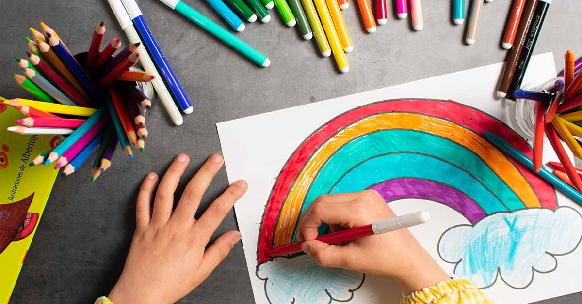 child painting a picture with school supplies