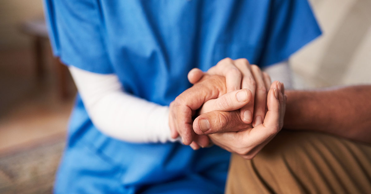 nurse hold senior patients hand
