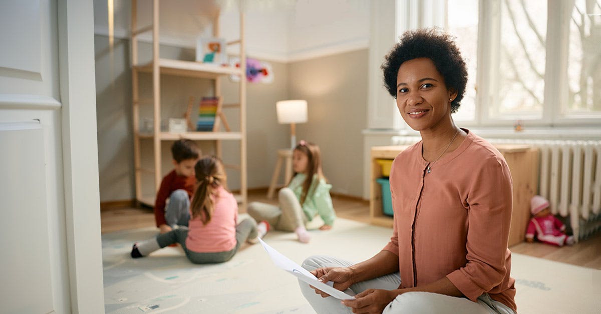childcare assistant sitting on the floor