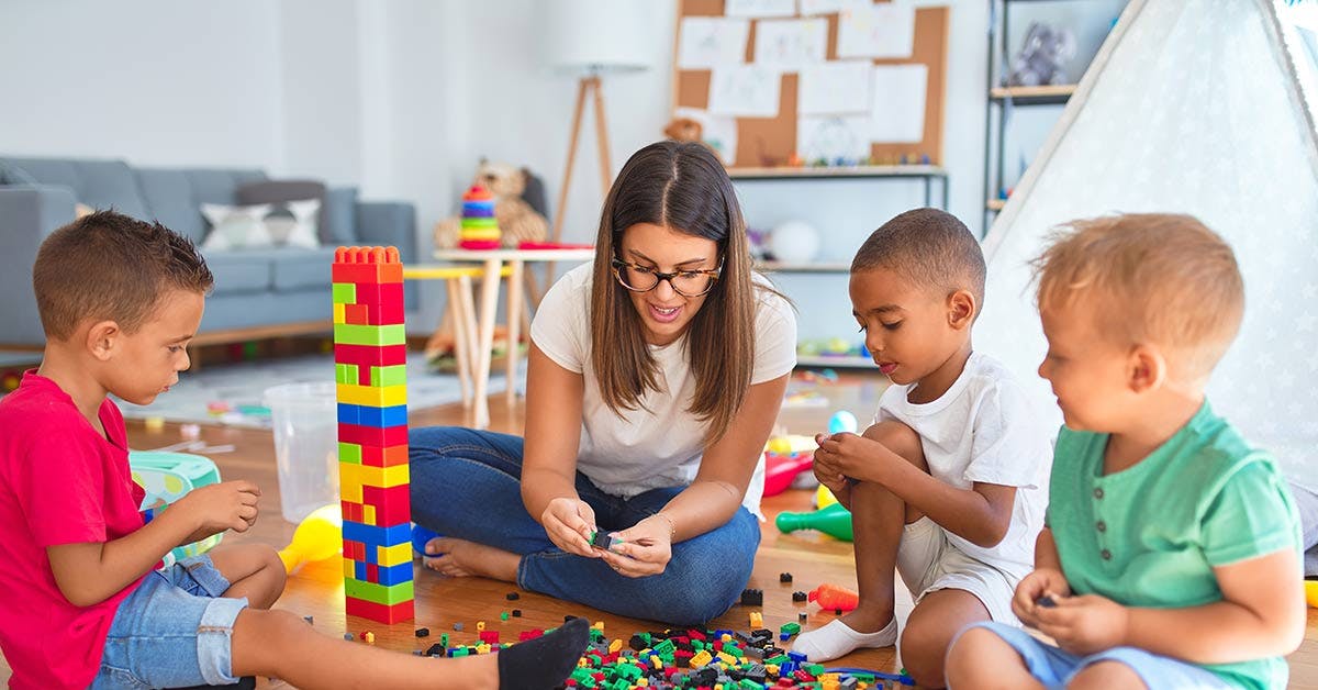 Early Childhood educator playing with building blocks