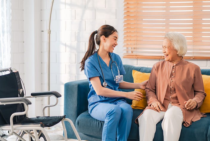 Student providing care to elderly woman at home