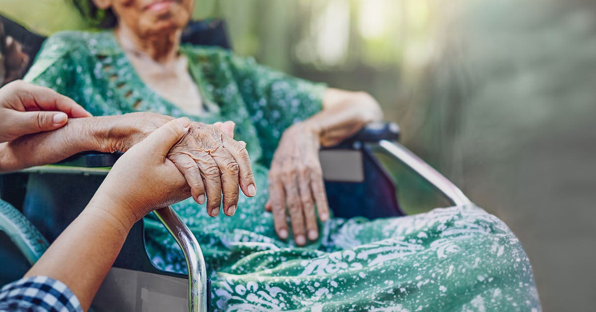 Aged Care Worker Holding Women's Hand